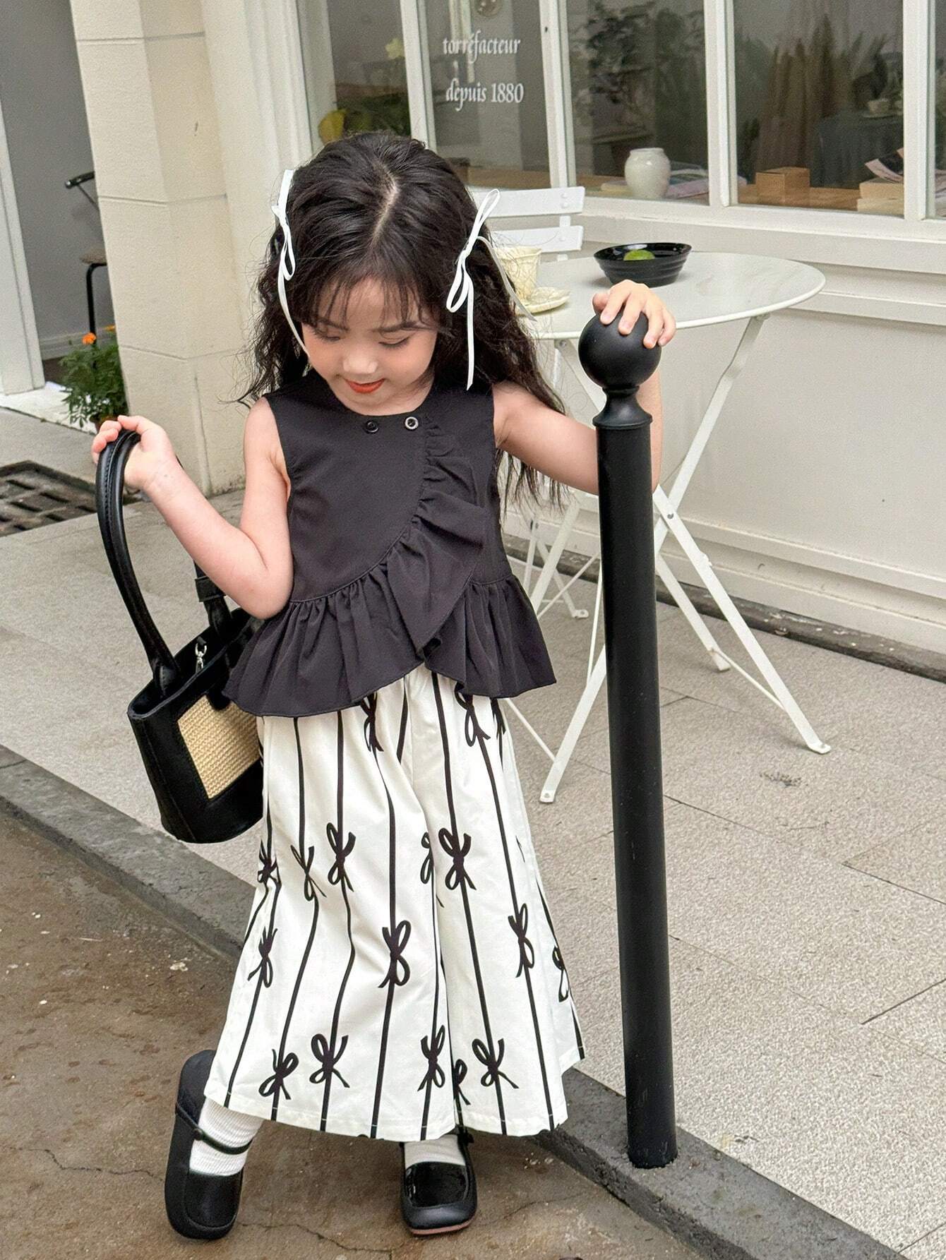 Young Girl Solid Color Round Neck Sleeveless Top With Ruffled Hem And All-Over Print Long Pants Black & White